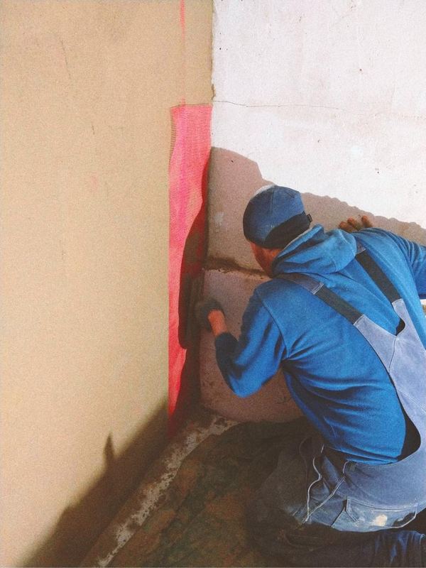 Fachkraft beim Auftragen von Lehmputz auf Innenwand